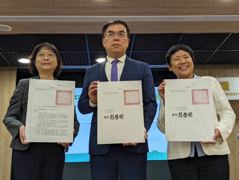環境部長彭啓明（中）與次長施文真（右）、氣候變遷署長蔡玲儀（左）昨日手持「碳費收費辦法」、「自主減量計畫管理辦法」及「碳費徵收對象溫室氣體減量指定目標」等碳費3子法公告文件，宣布排碳有價時代來臨。（中央社提供）