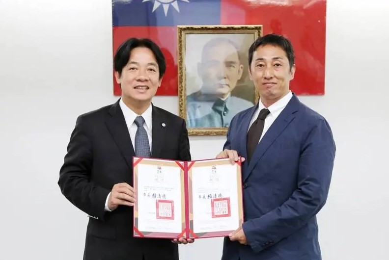 圖為時任台南市長賴清德（左）2016年頒發台南市城市外交顧問給野崎孝男（右）。（圖截取自賴清德臉書）