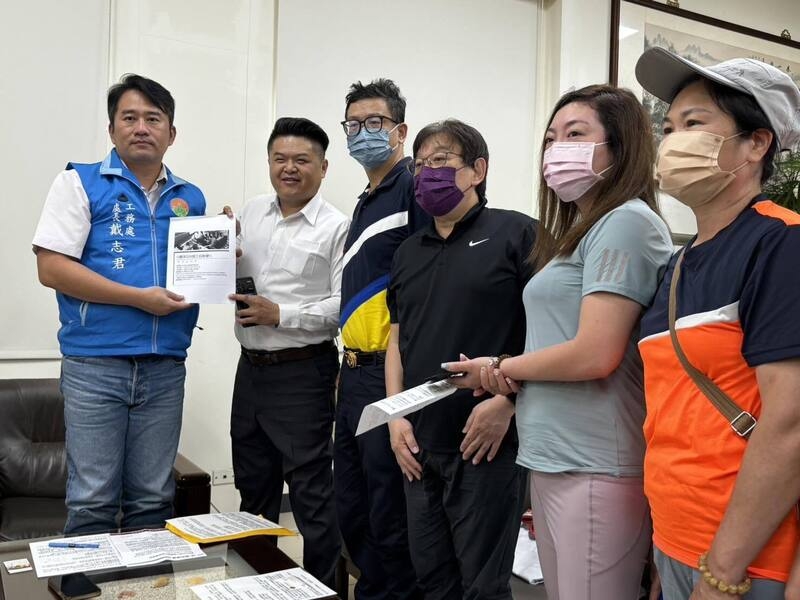新竹縣「豐采520」因天坑事件停工，已購住戶集結成立自救會，10日到縣府工務處陳情，盼盡快審查建案相關申請程序加速復工，工務處長戴志君接下陳情書。 中央社記者郭宣彣攝