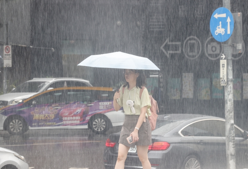 民眾撐傘擋雨。( 中央社記者謝佳璋攝)