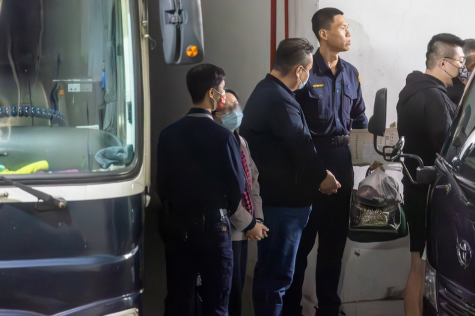 劉姓保母在法警移送下步行上警備車。（中央社提供）