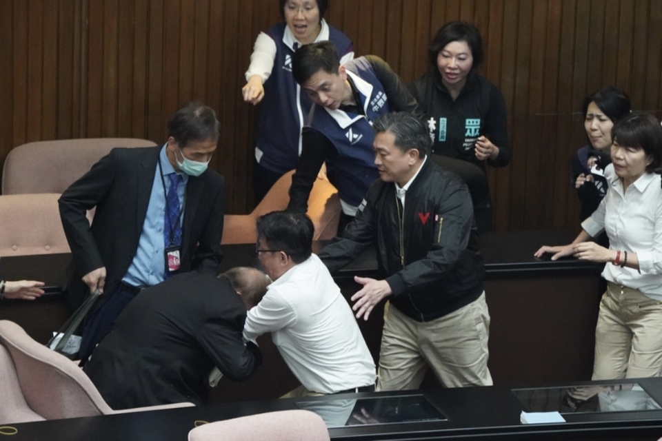 立法院5月17日曾爆發朝野衝突，當時郭國文（前右三白衣者）一把搶走周萬來（前左）手上的資料，引發批評。（資料照，中央社提供）