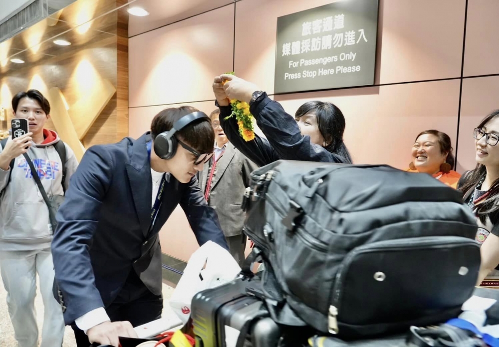 伍麗華為吳俊偉戴花環。擷取自中央社（伍麗華辦公室提供；記者黃郁菁傳真）。