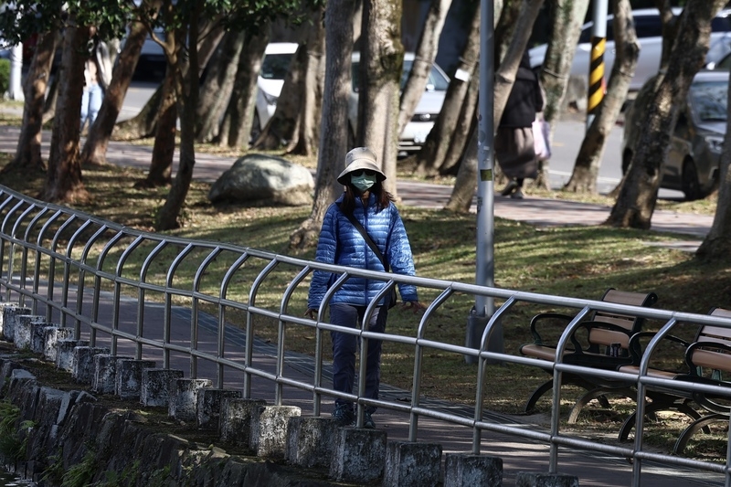 圖為台北市內湖區民眾穿羽絨外套、戴帽子禦寒。 (中央社記者翁睿坤攝)